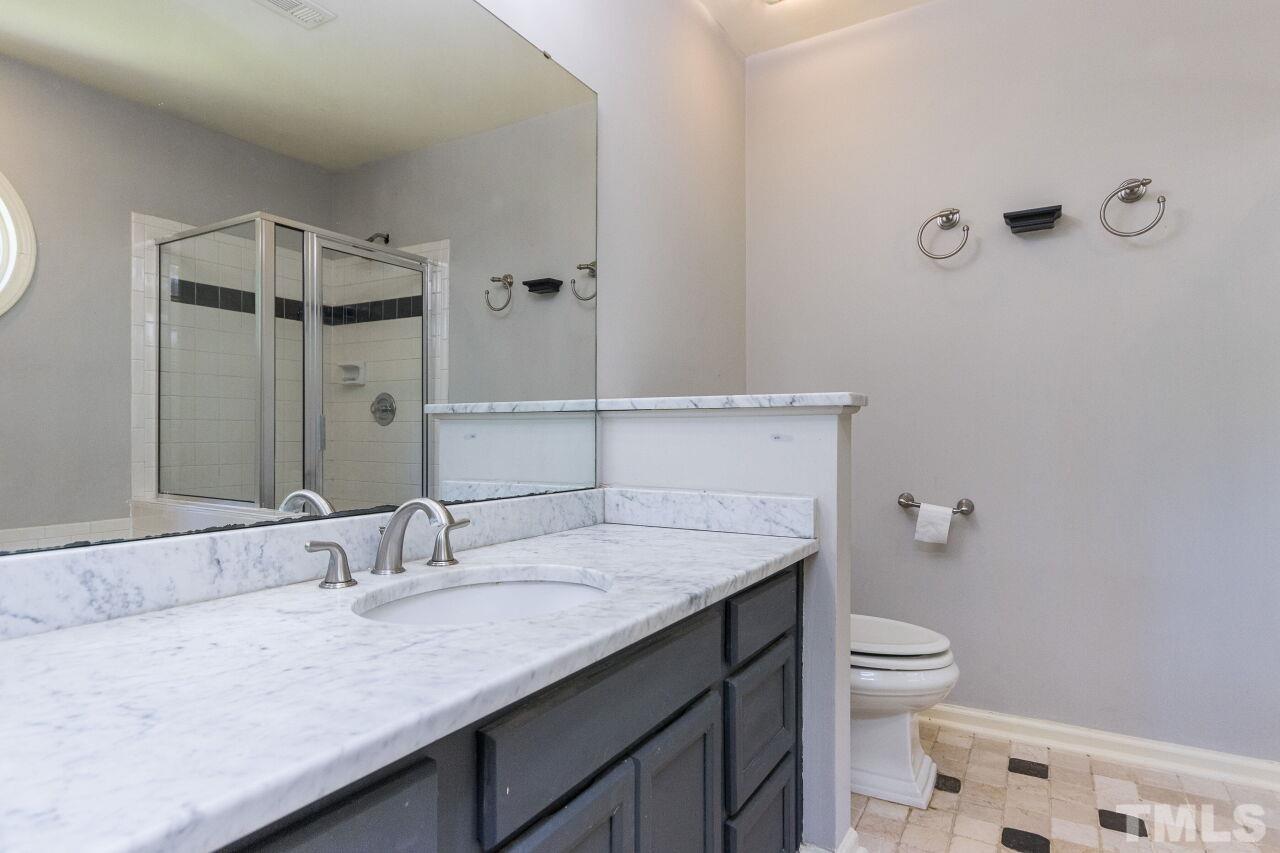 2400 Long And Winding Road Raleigh, NC 27603 - Photo 24 of 29 a bathroom with a granite countertop sink and a mirror