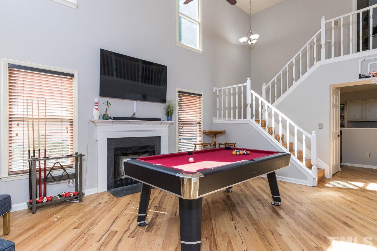 2400 Long And Winding Road Raleigh, NC 27603 - Photo 6 of 29 a living room with furniture pool table flat screen tv and a floor to ceiling window