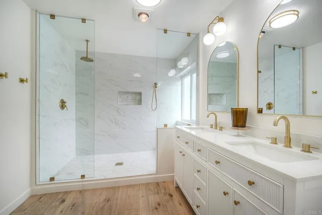 a bathroom with double vanity sinks a vanity a lamp and a mirror