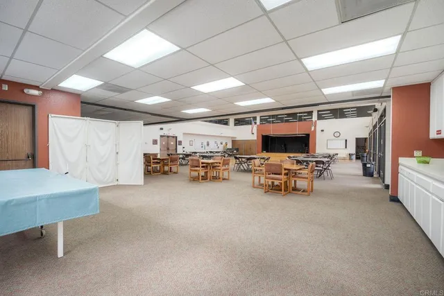 a view of a house with floor to ceiling windows and yard