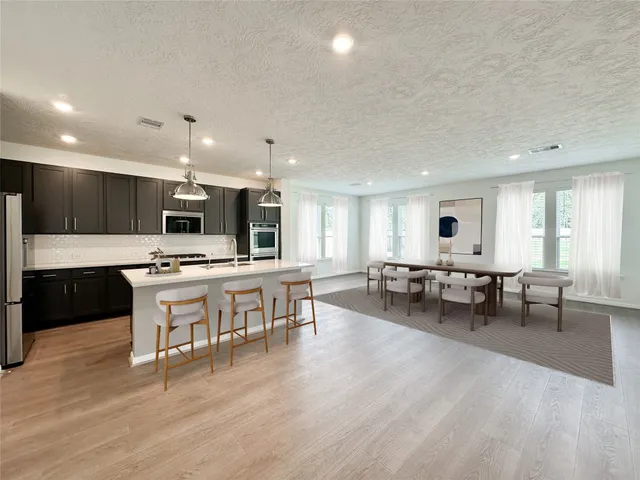 a large kitchen with lots of counter space and dining table