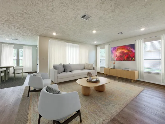 a living room with furniture and a wooden floor