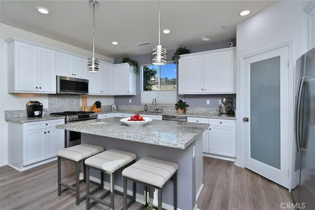 a kitchen with kitchen island granite countertop a sink and wooden cabinets