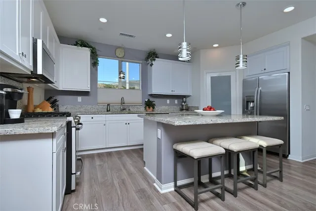 a kitchen with granite countertop a stove a sink and a microwave