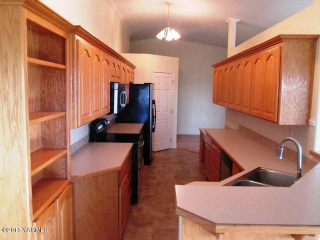 173401 West Johnson Road Grandview, WA 98930 - Photo 16 of 38 a kitchen that has a sink and a chair in it