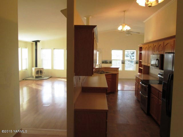 173401 West Johnson Road Grandview, WA 98930 - Photo 32 of 38 a view of a living room with a fireplace furniture and a kitchen view