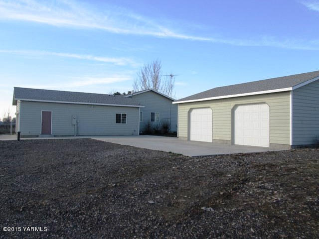 173401 West Johnson Road Grandview, WA 98930 - Photo 6 of 38 a front view of a house with a yard and garage