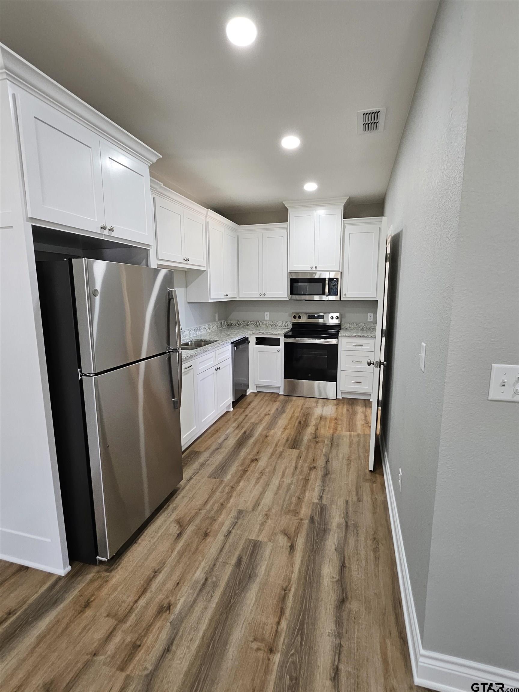100 Cook Street, Unit 3 Arp, TX 75750 - Photo 2 of 7 a kitchen with granite countertop a refrigerator a sink and dishwasher