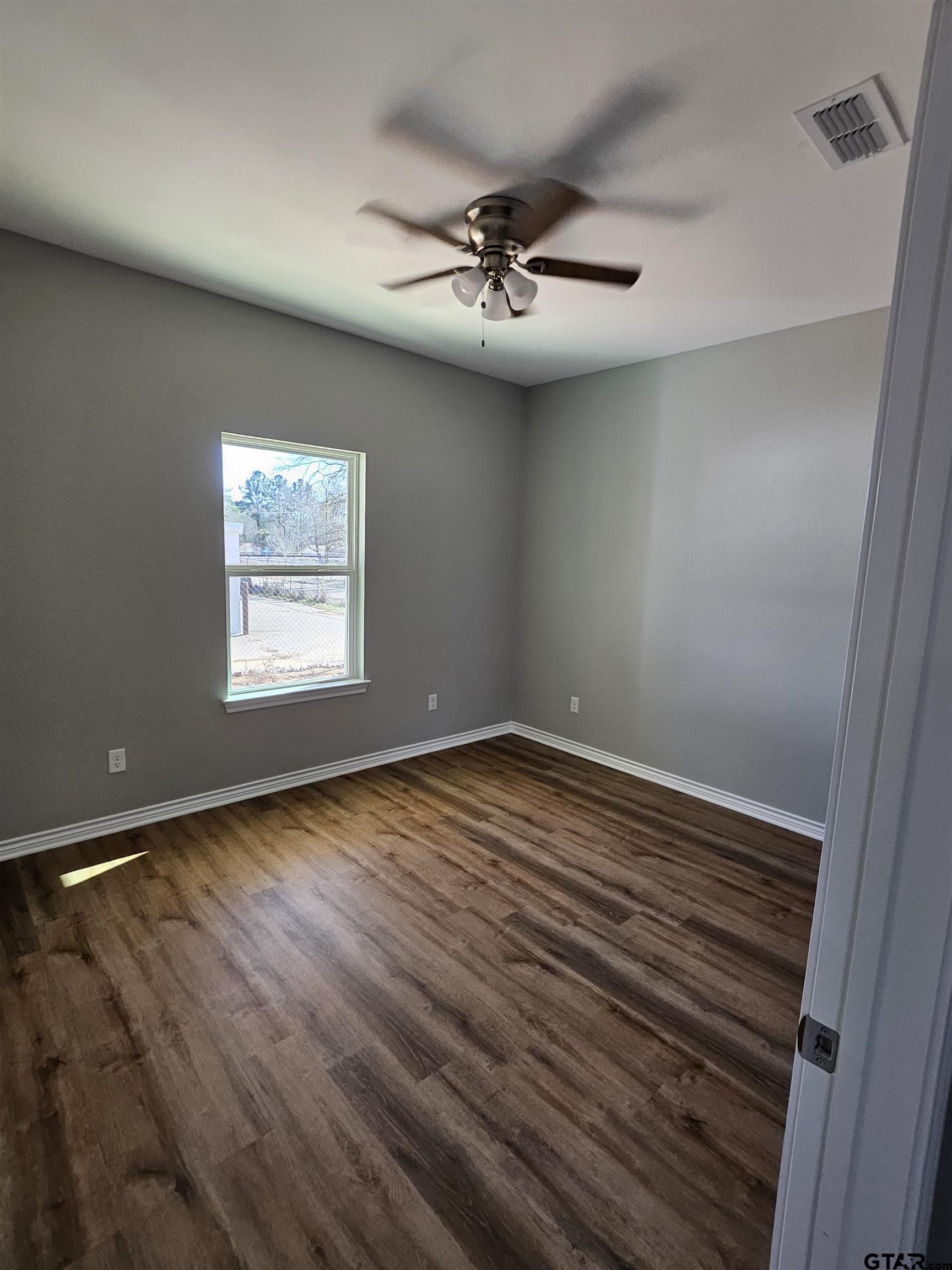 100 Cook Street, Unit 3 Arp, TX 75750 - Photo 6 of 7 an empty room with wooden floor and windows