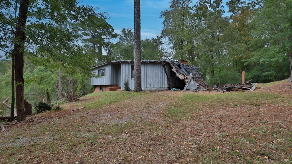 a view of a house with backyard and trees