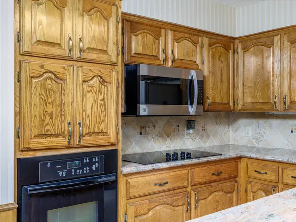 a kitchen with stainless steel appliances granite countertop a stove a sink and a microwave