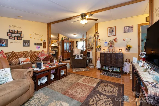 a living room with furniture a flat screen tv and a refrigerator