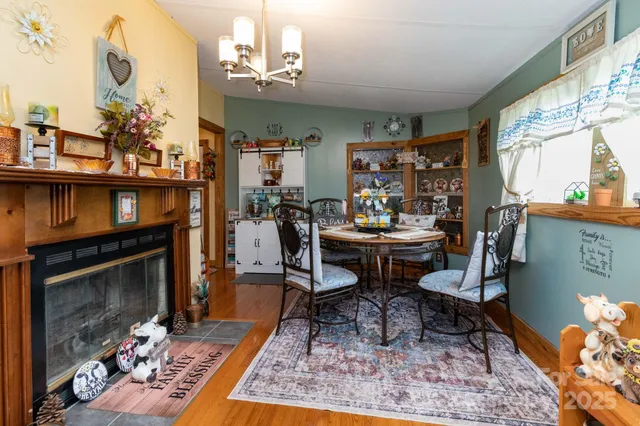 a living room with furniture a rug a fireplace and a large window