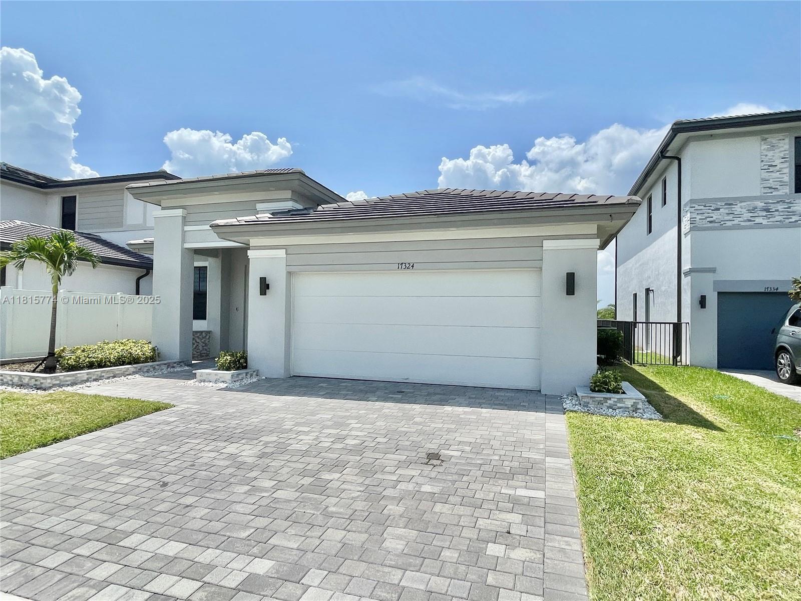 17324 Southwest 41st Street, Unit 17324 Miramar, FL 33029 - Photo 29 of 30 a front view of a house with a yard and garage