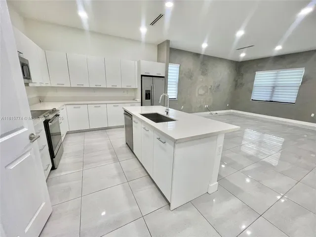 a kitchen that has a sink a stove a microwave and a counter top space