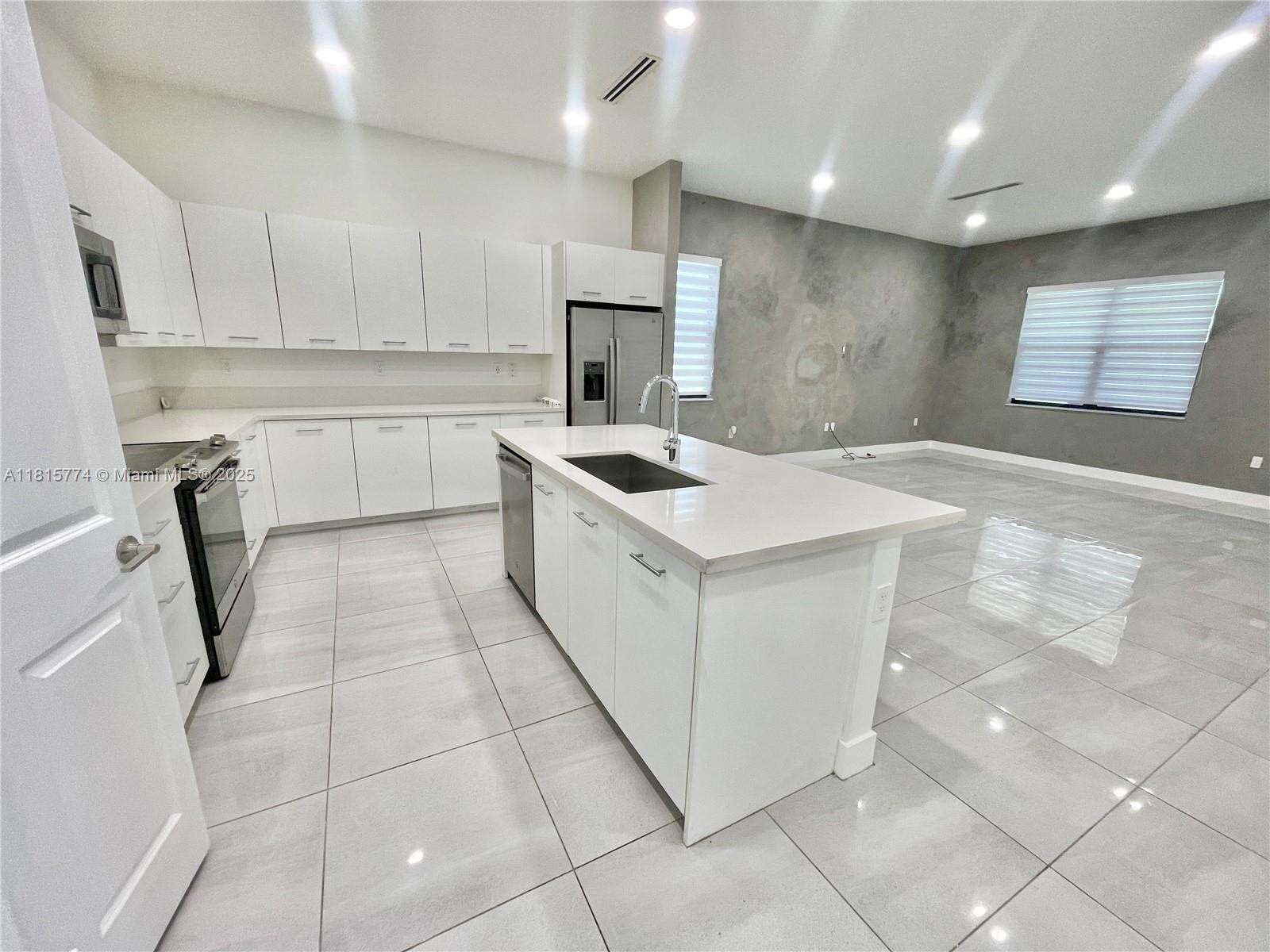 17324 Southwest 41st Street, Unit 17324 Miramar, FL 33029 - Photo 5 of 30 a kitchen that has a sink a stove a microwave and a counter top space