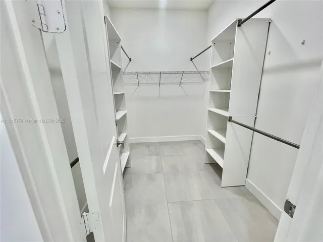 a view of walk in closet with empty racks