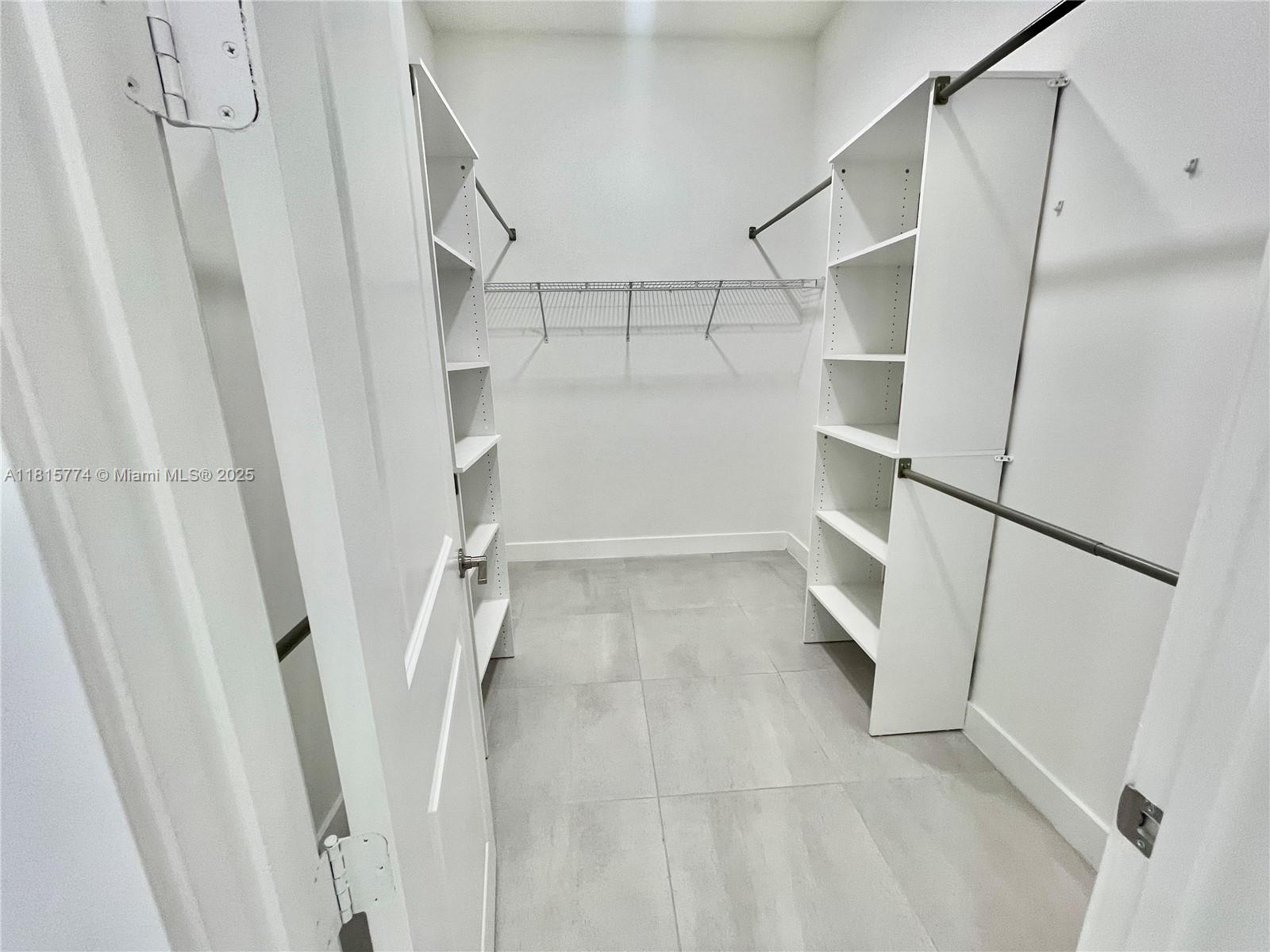 17324 Southwest 41st Street, Unit 17324 Miramar, FL 33029 - Photo 8 of 30 a view of walk in closet with empty racks