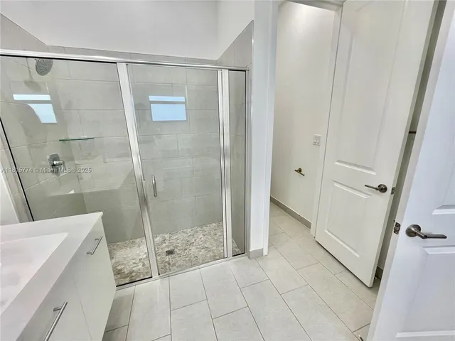 a bathroom with a shower and a sink a mirror