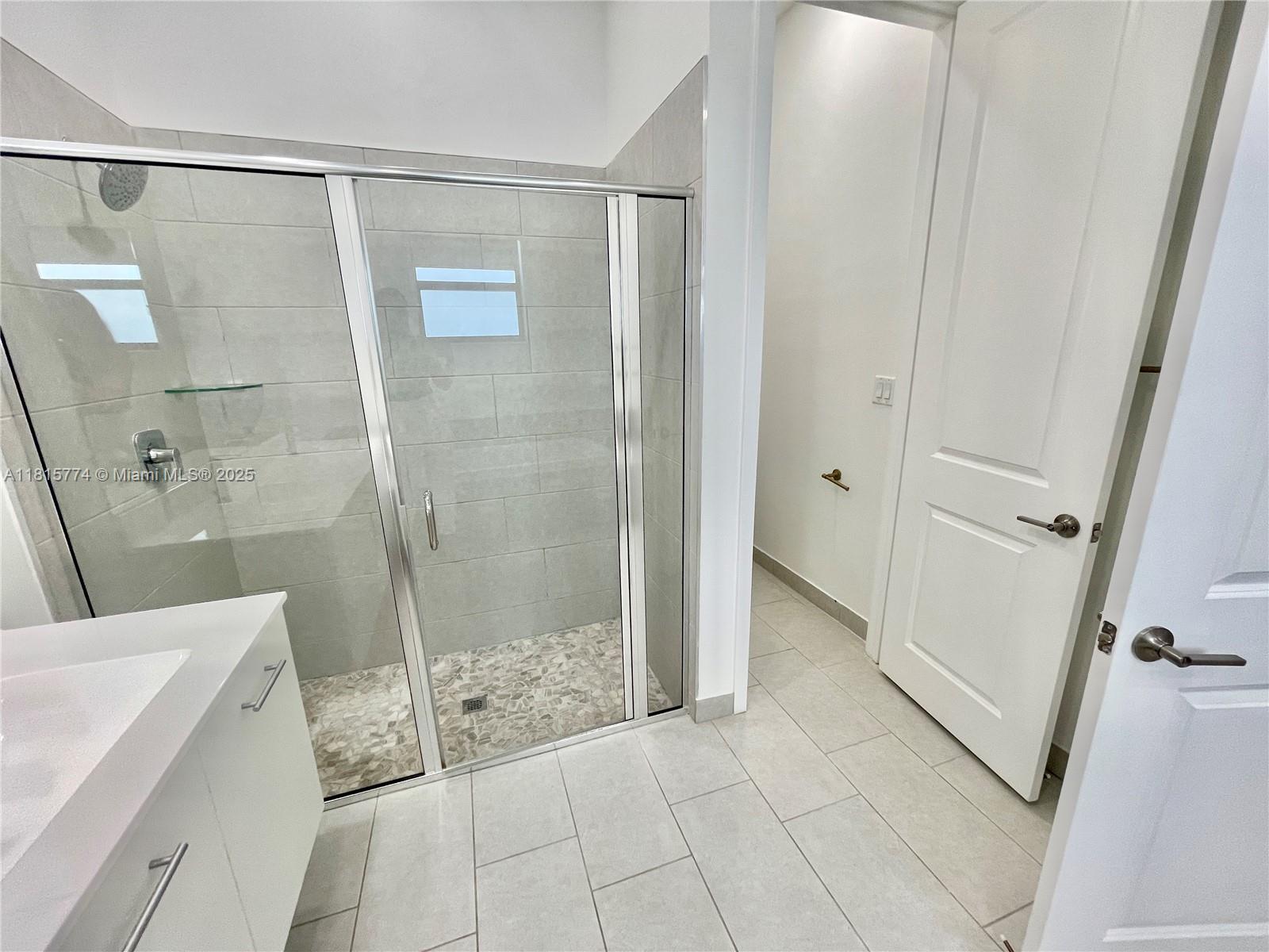 17324 Southwest 41st Street, Unit 17324 Miramar, FL 33029 - Photo 9 of 30 a bathroom with a shower and a sink a mirror