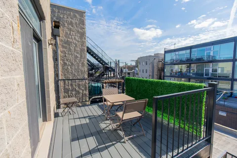 a view of a roof deck with dining table and chairs