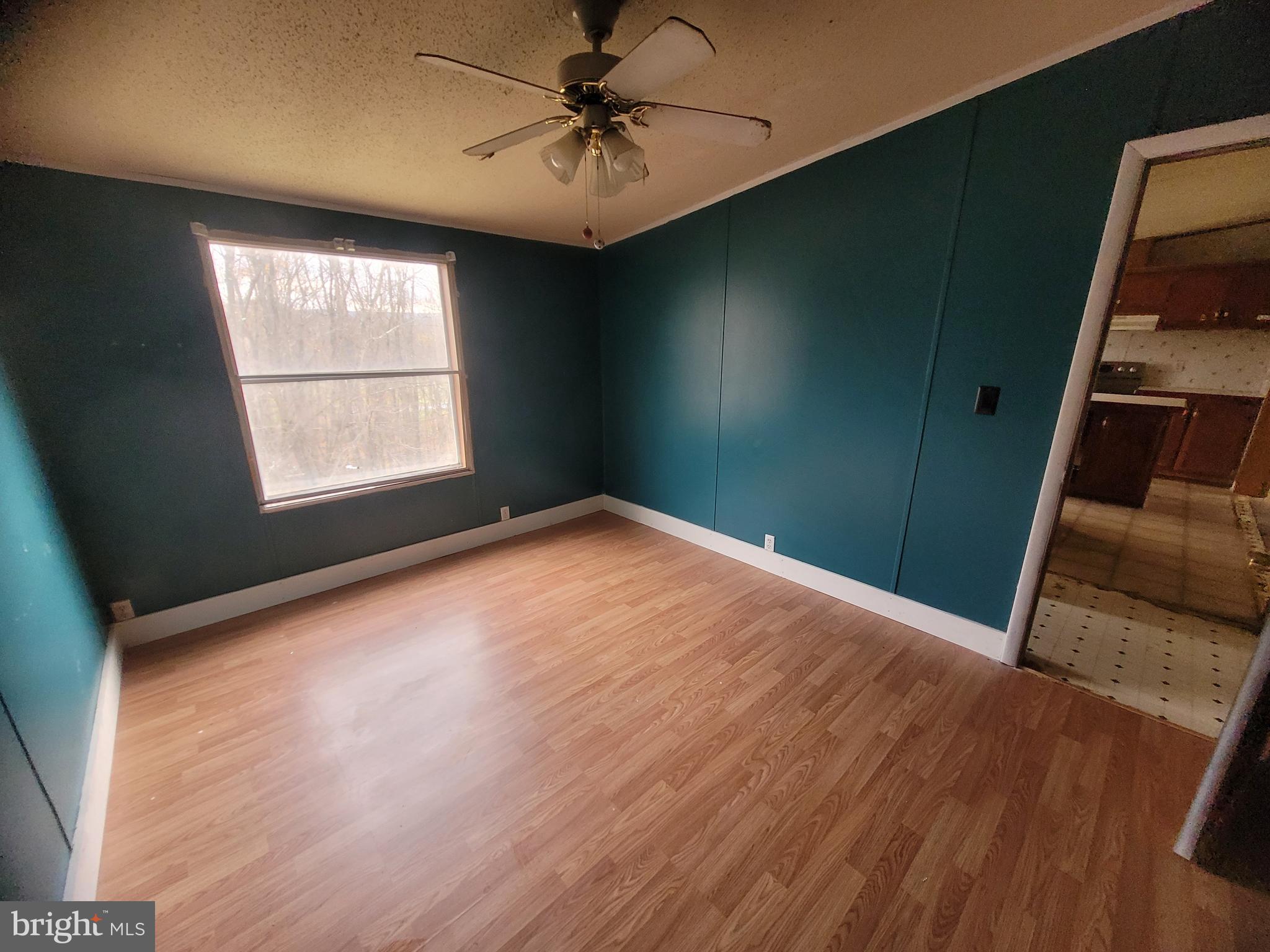 13518 Blank Road Northwest Mount Savage, MD 21545 - Photo 14 of 36 an empty room with wooden floor fan and windows