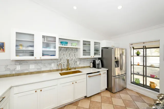 a kitchen with a sink a refrigerator and cabinets