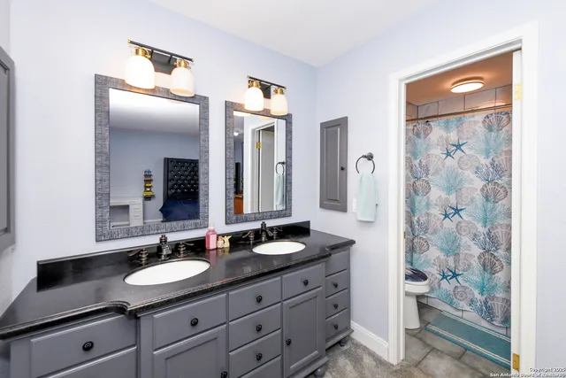 a bathroom with a granite countertop sink and a mirror