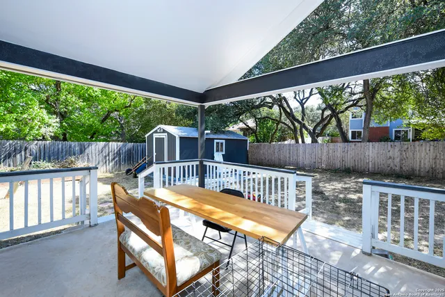 a view of a patio with a table chairs and a backyard
