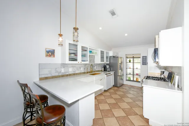 a kitchen with a dining table chairs and white cabinets