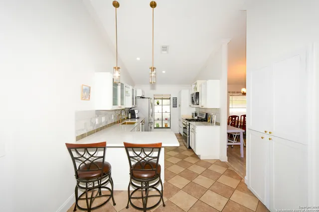 a kitchen with stainless steel appliances kitchen island granite countertop a table and chairs in it