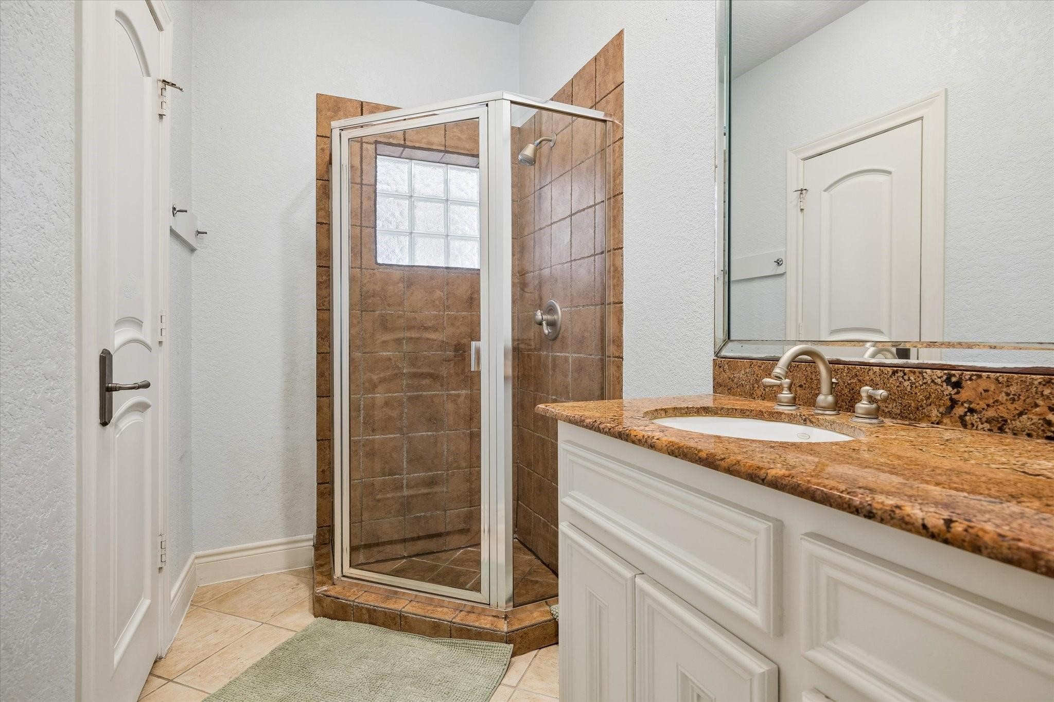 2128 Harold Street, Unit A Houston, TX 77098 - Photo 12 of 14 a bathroom with a granite countertop sink and a mirror