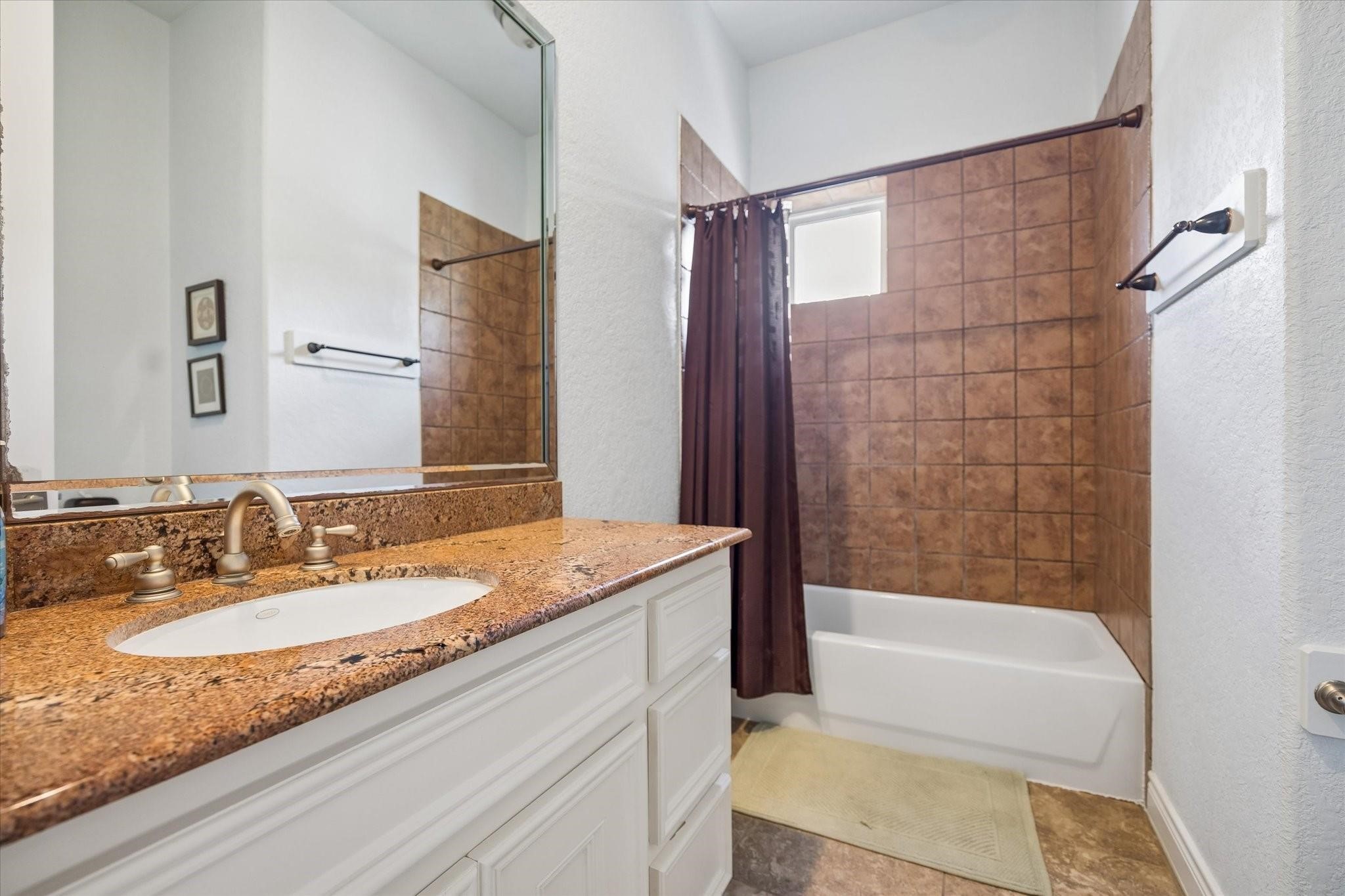 2128 Harold Street, Unit A Houston, TX 77098 - Photo 6 of 14 a bathroom with a granite countertop tub sink and mirror