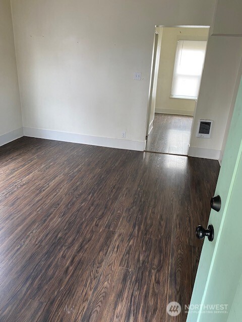 547 South Sullivan Street Seattle, WA 98108 - Photo 3 of 17 an empty room with wooden floor and windows