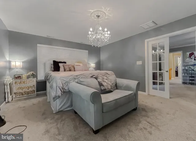 a bedroom with a bed and a chandelier