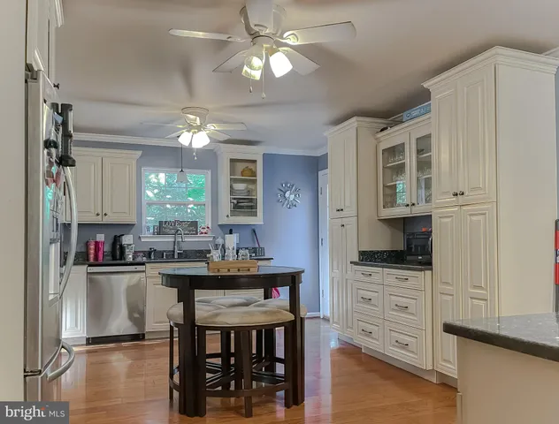 a kitchen with stainless steel appliances kitchen island granite countertop a stove and cabinets