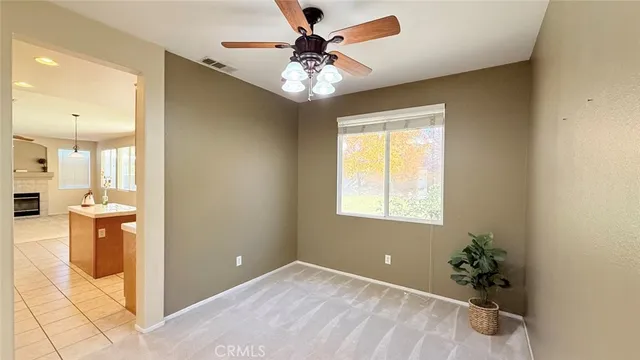 a view of a livingroom with a fireplace a chandelier fan and windows