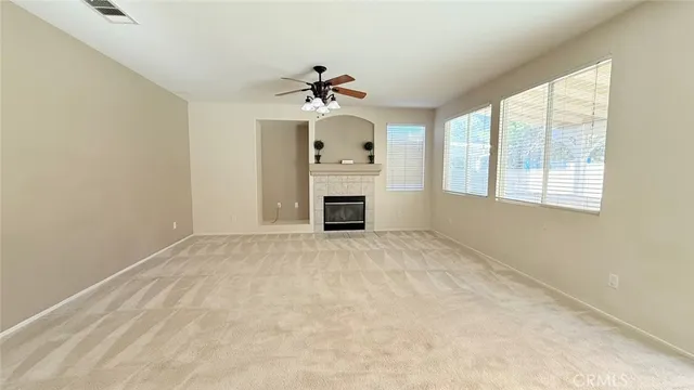 a view of an empty room with a window and a kitchen