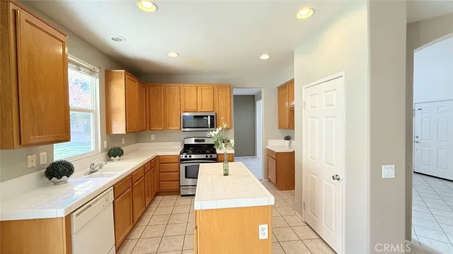 a kitchen with a refrigerator a stove top oven a sink and cabinets