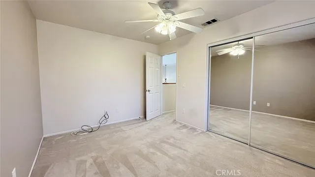an empty room with a ceiling fan and a shower