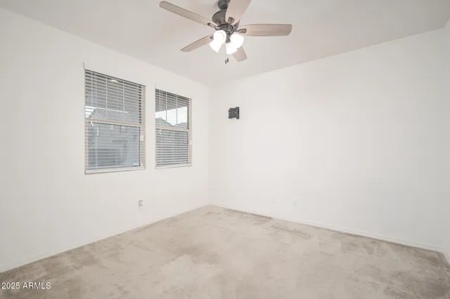 an empty room with a window and a ceiling fan