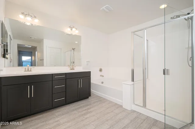 a spacious bathroom with a tub sink and mirror