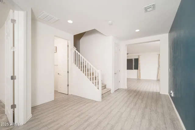 a view of a hallway with wooden floor and staircase