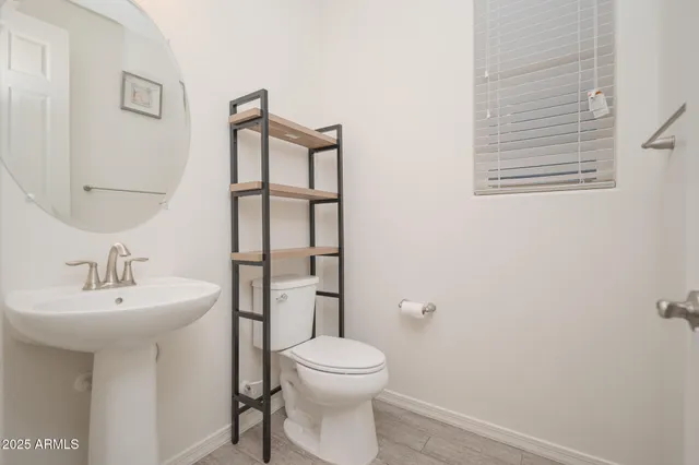 a bathroom with a toilet a sink and mirror
