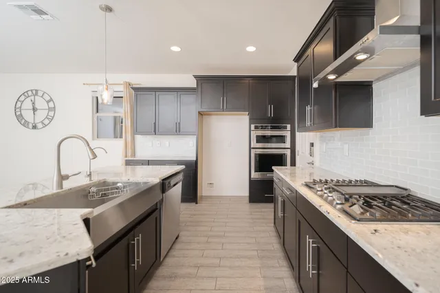 a kitchen with stainless steel appliances granite countertop a sink stove and refrigerator