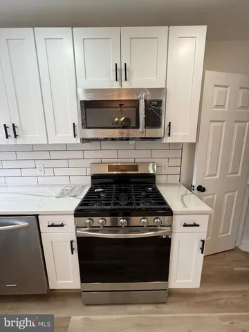 a stove top oven sitting inside of a kitchen