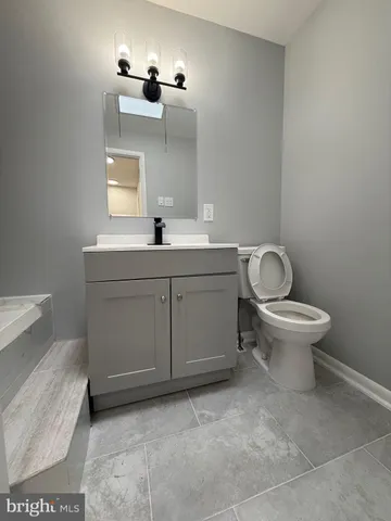 a bathroom with a toilet sink and mirror