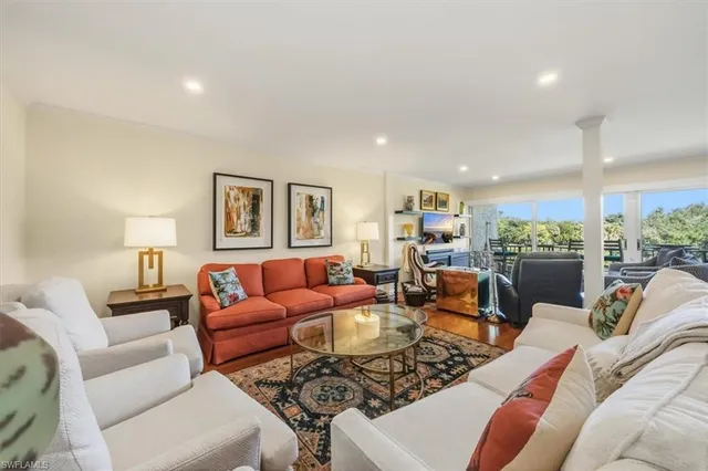 a living room with furniture kitchen view and a large window