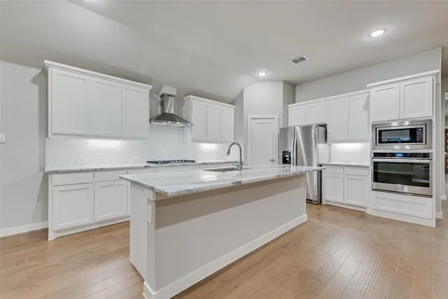 a kitchen with stainless steel appliances granite countertop a stove and a refrigerator