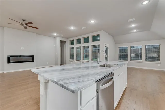 an empty room with a kitchen and windows